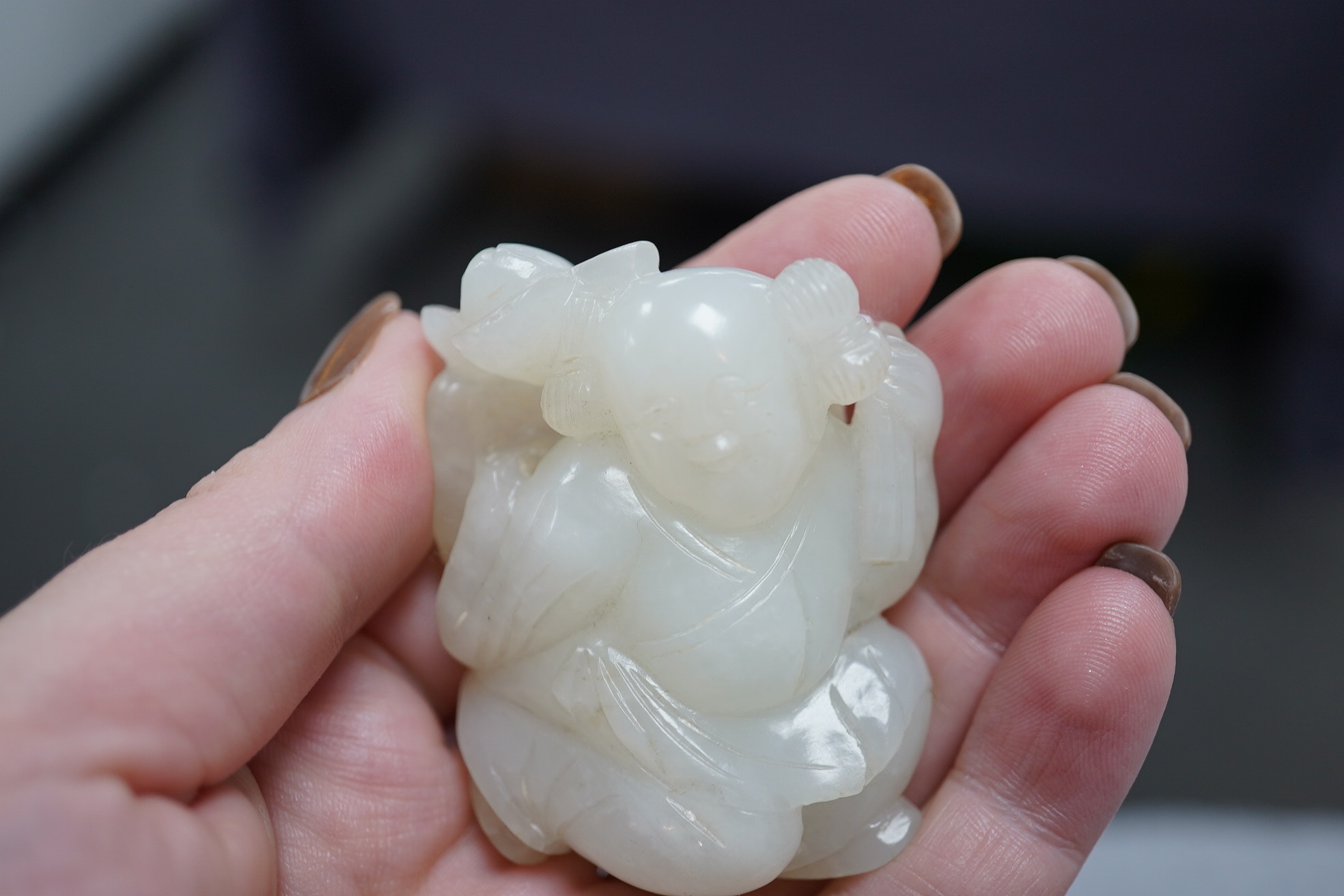 A Chinese white jade figure of a kneeling boy holding lingzhi fungus, 19th century